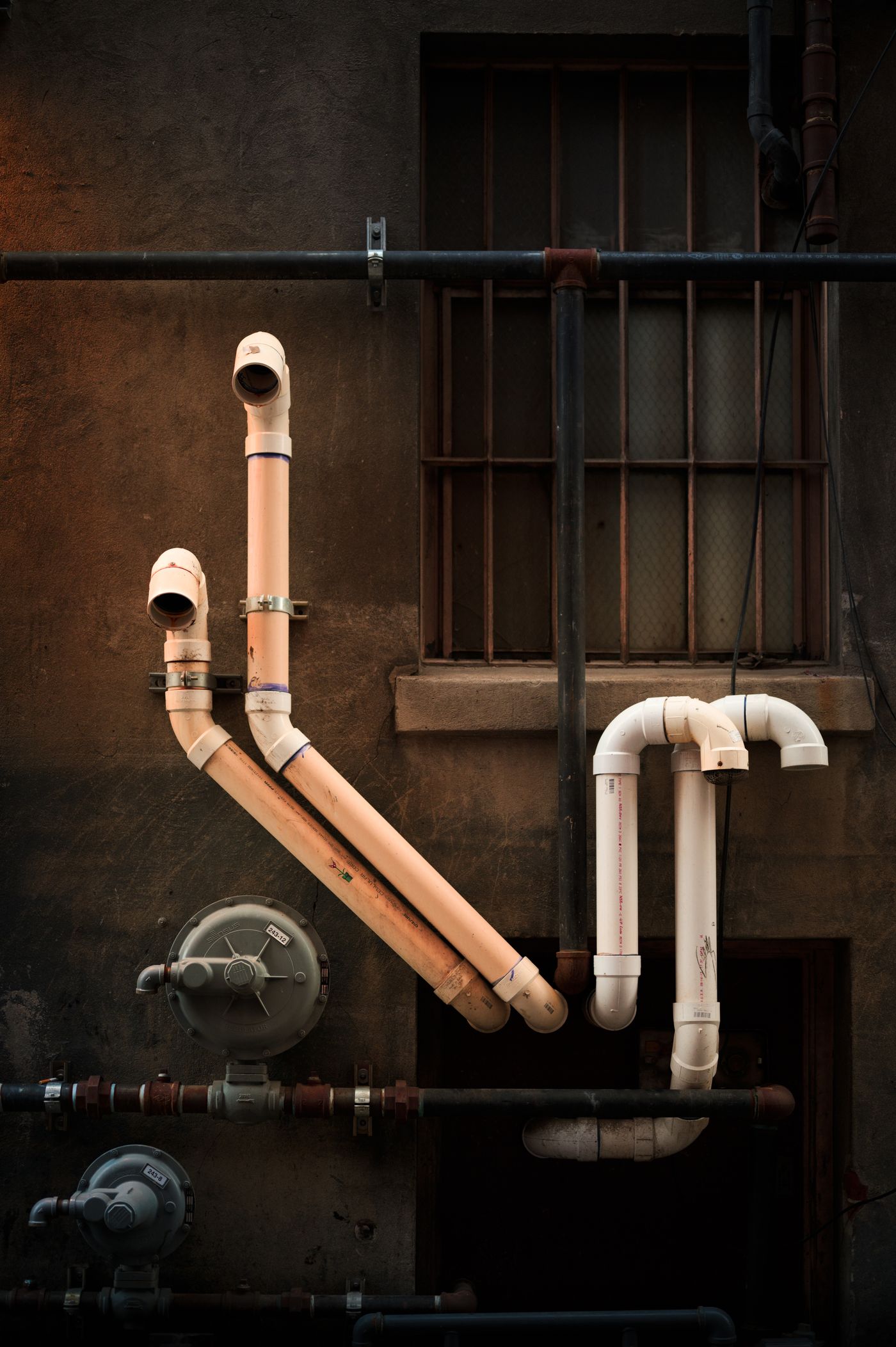 Exterior plumbing pipes in low light
