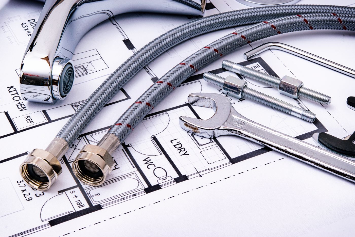 Plumbing fixtures and tools laid over a bathroom plan