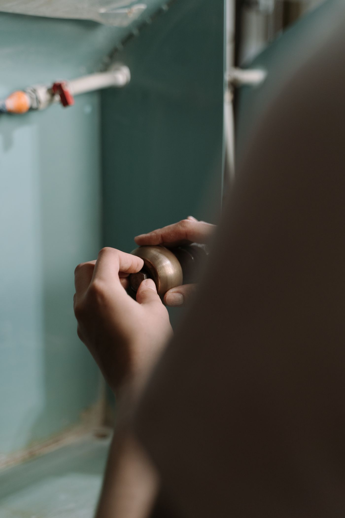 Plumber working under a sink during an emergency plumbing repair